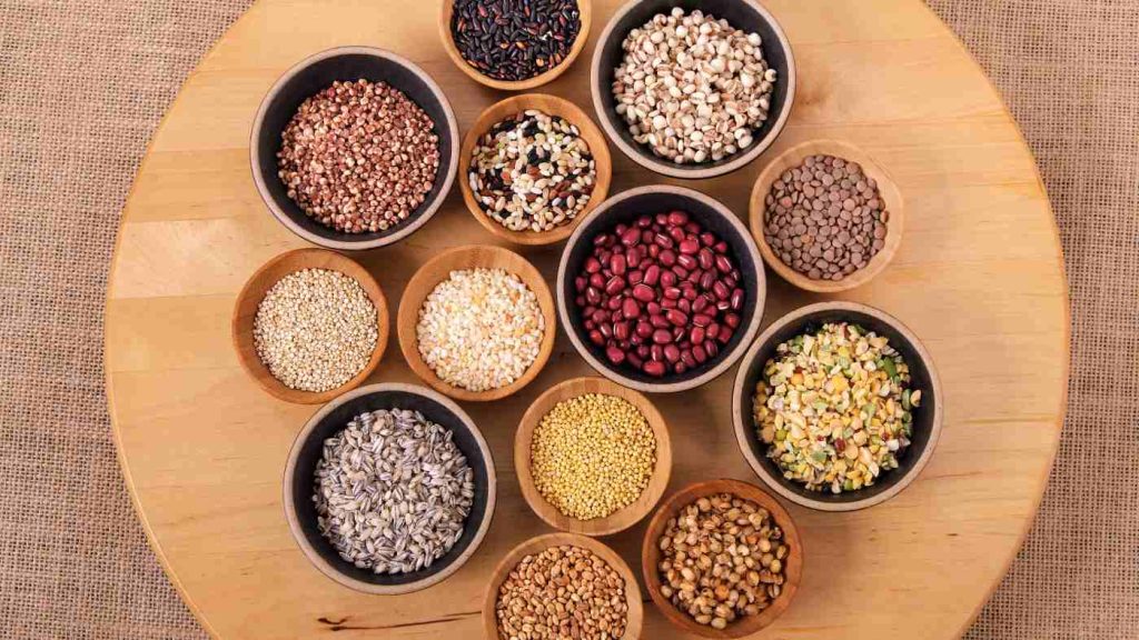 Various nutrient-rich grains, seeds, and legumes in bowls, showcasing foods that support better teen mental health and brain function.