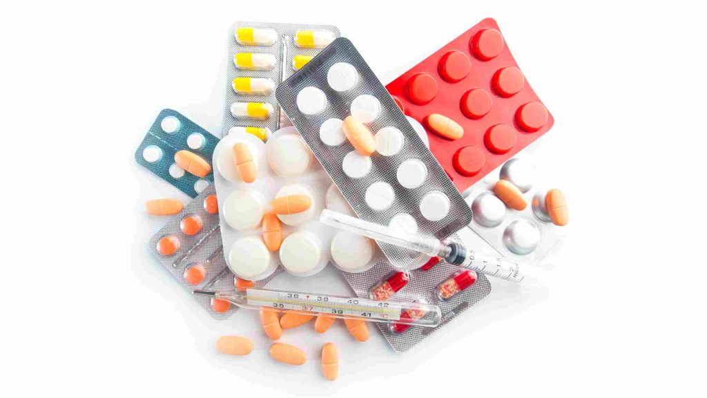 Assorted medication blister packs, capsules, and a syringe, symbolizing ADHD treatment options after diagnosis.