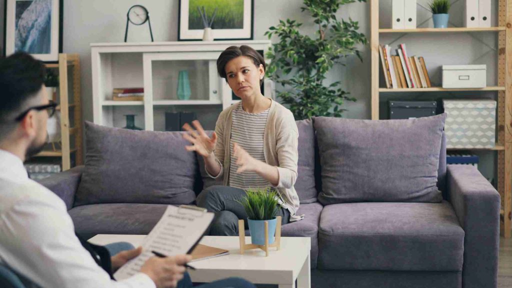 Parent speaking with a therapist in an office, illustrating professional help for parents of disobedient teens.