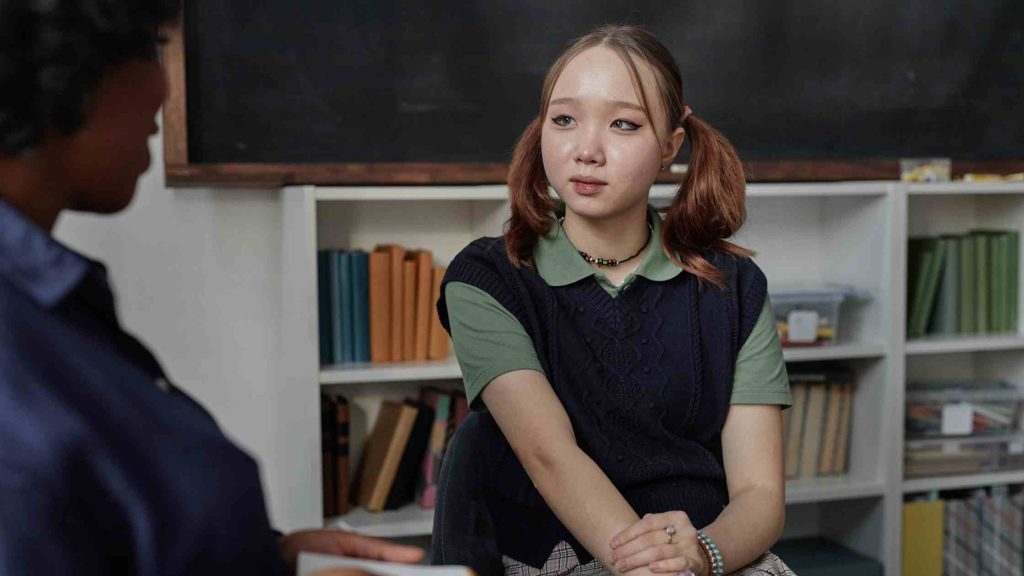 Teen talking to a therapist in an office, illustrating professional help and guidance for a rebellious teen.