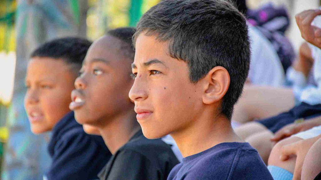 Focused teenage boys sitting outdoors, symbolizing different types of boys’ homes like residential treatment centers.