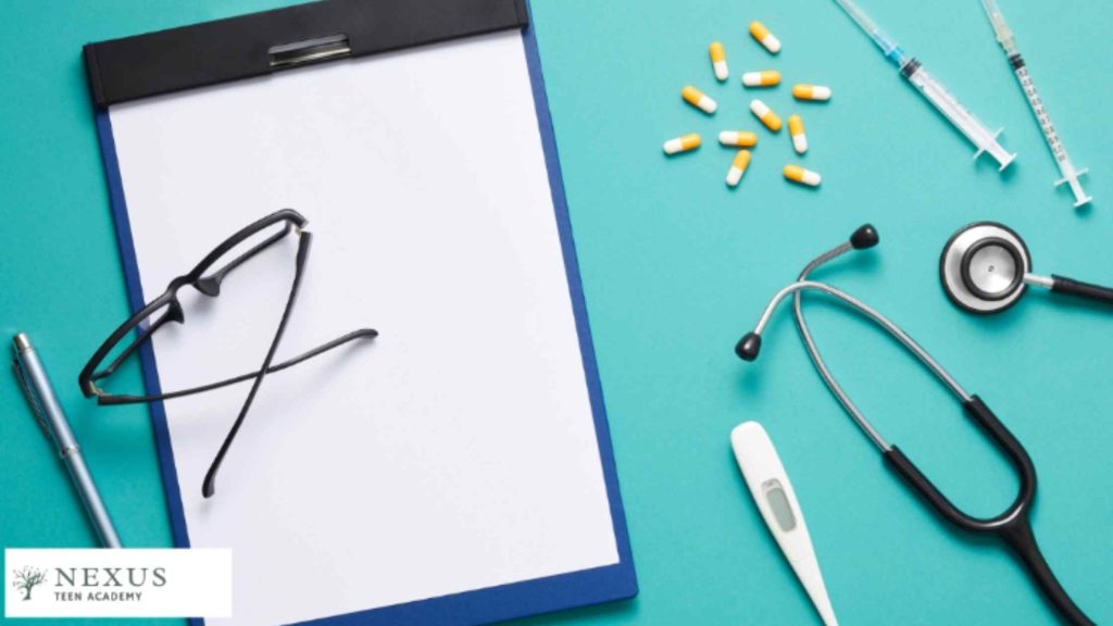 Medical tools, clipboard, and pills on a teal surface symbolizing diagnosis and treatment options for conduct disorder.