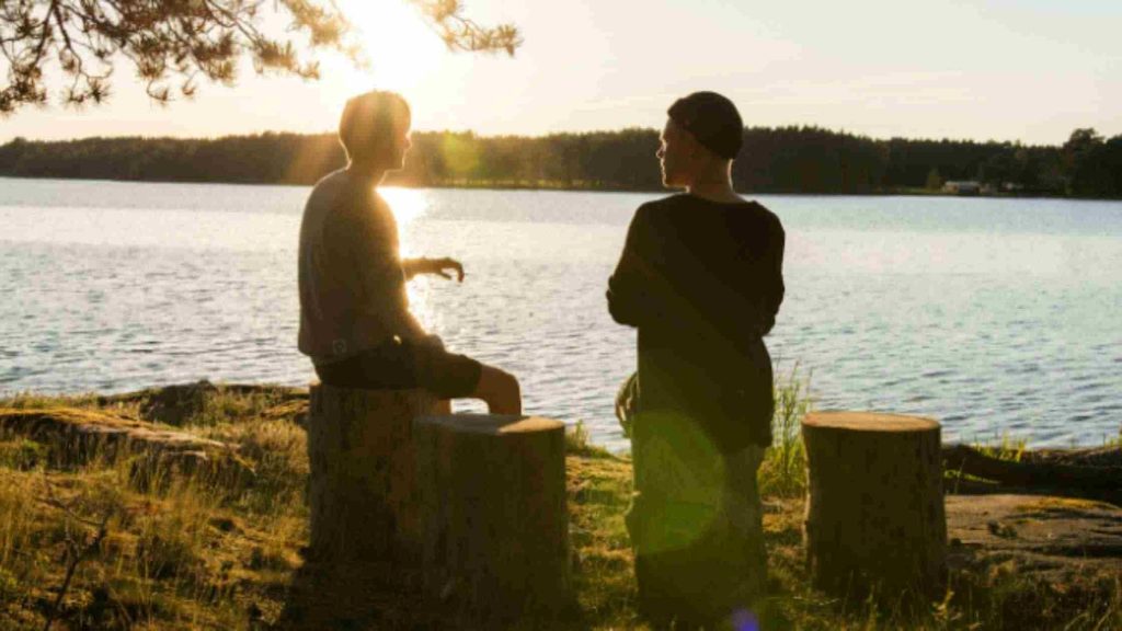 A teen talking quietly with a parent, illustrating a supportive conversation about a police incident and seeking treatment.