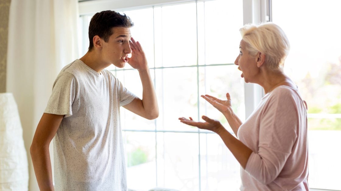 Teen boy arguing with parent at home, showing anger and emotional overwhelm linked to fear of failure among teens.