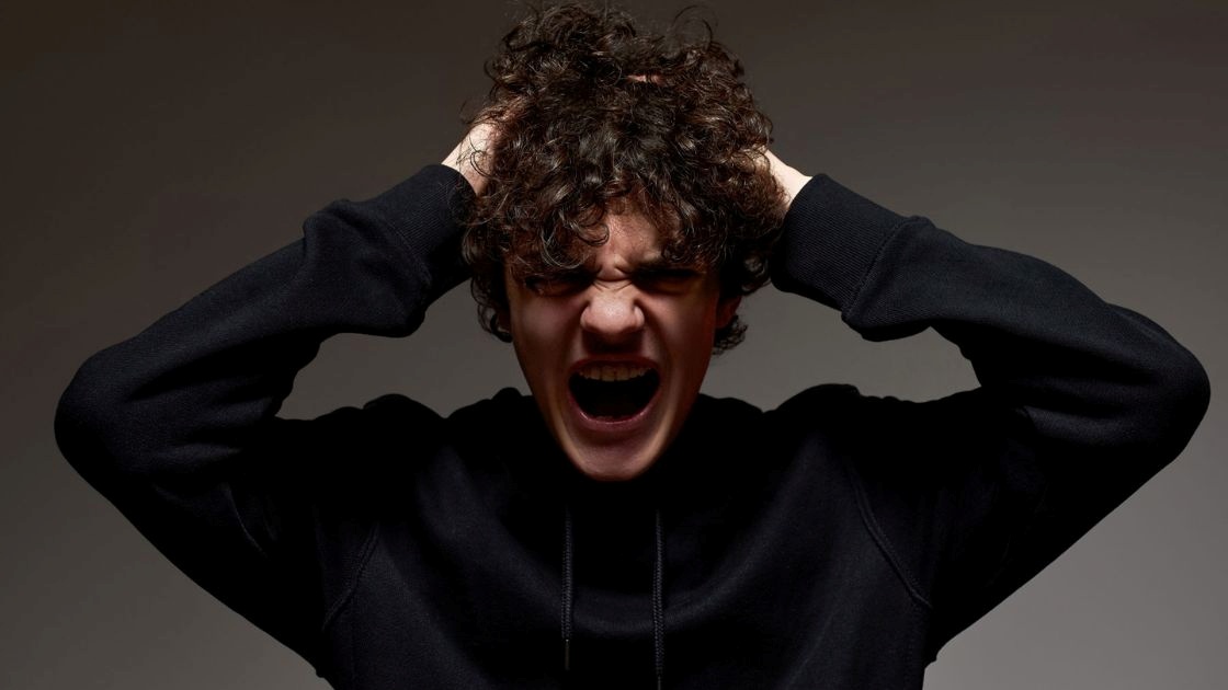 Teen boy screaming angrily; symbolizes anger-based depression and emotional overwhelm linked to teen brain development.