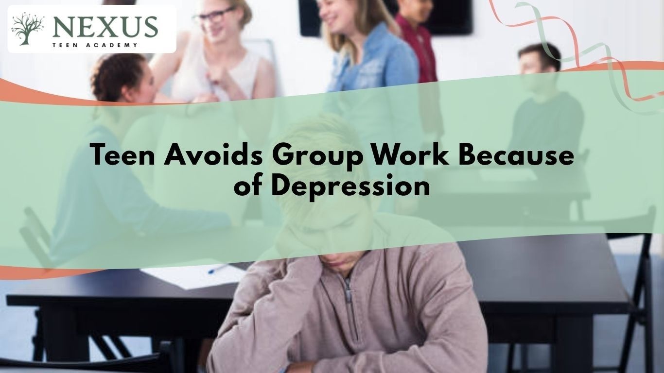 Depressed teen avoiding group work and sitting alone in classroom