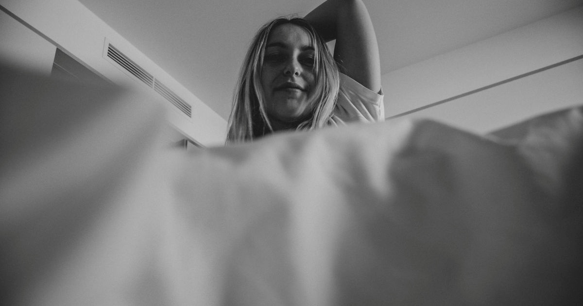 Parent checking on a teen in bed while building healthier routines after families can't get kid out of bed consistently.