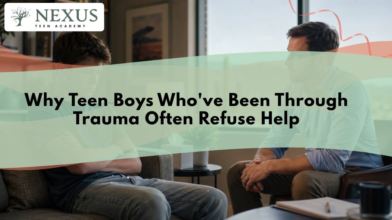 Teen boy sits with head down during a therapy session, reflecting why teen boys refuse help after trauma.